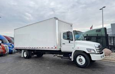 White box truck parked outside a dealership lot, representing medium-duty inventory.