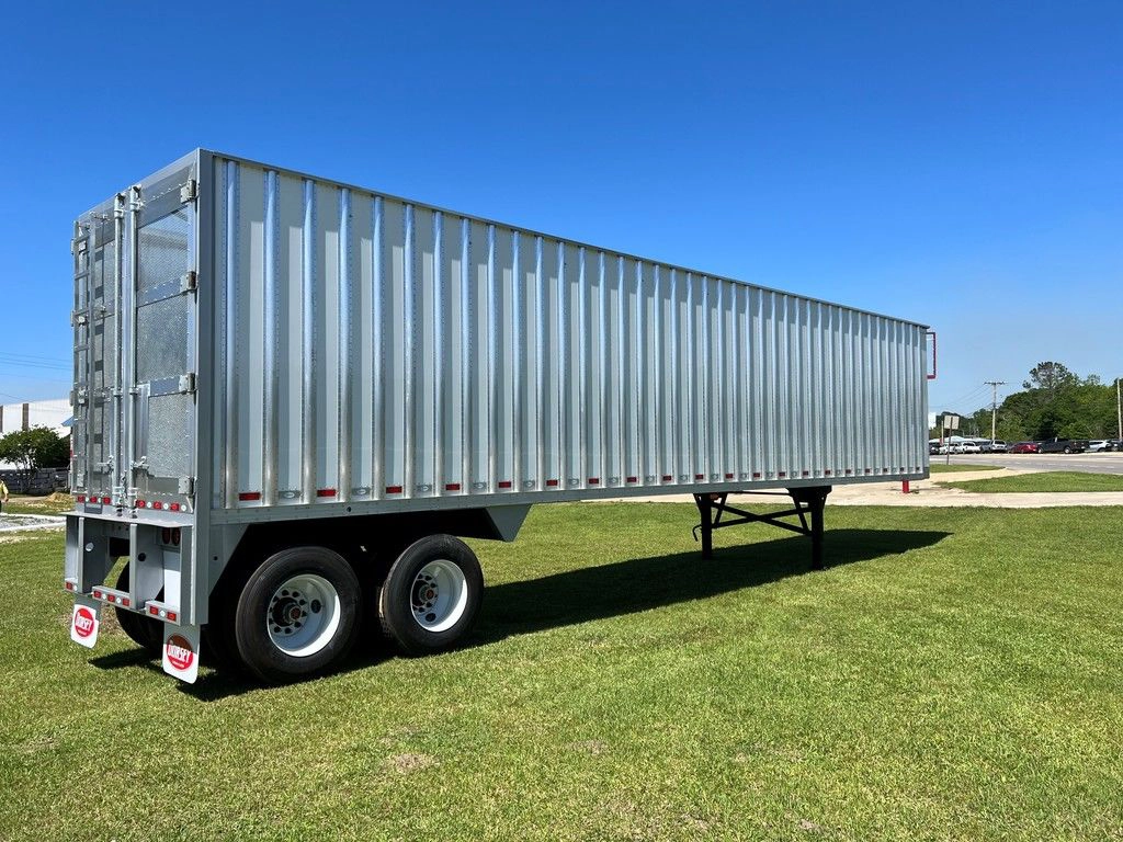 Silver Dorsey chip van trailer shown from the rear side on a grassy lot.