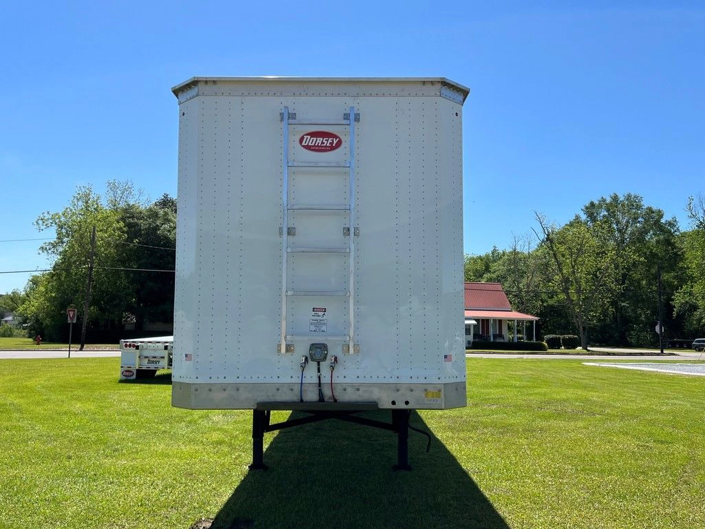 Front view of a white Dorsey chip van trailer parked on grass.