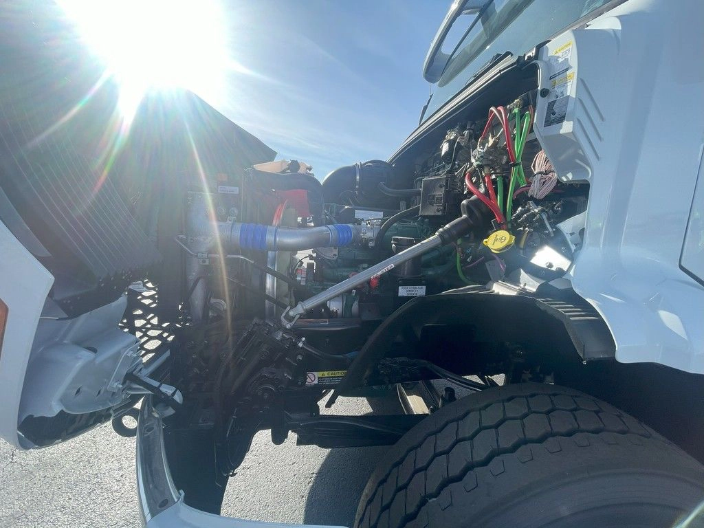 Open hood view of the Volvo VNR engine bay, showing suspension, tire and service access points.
