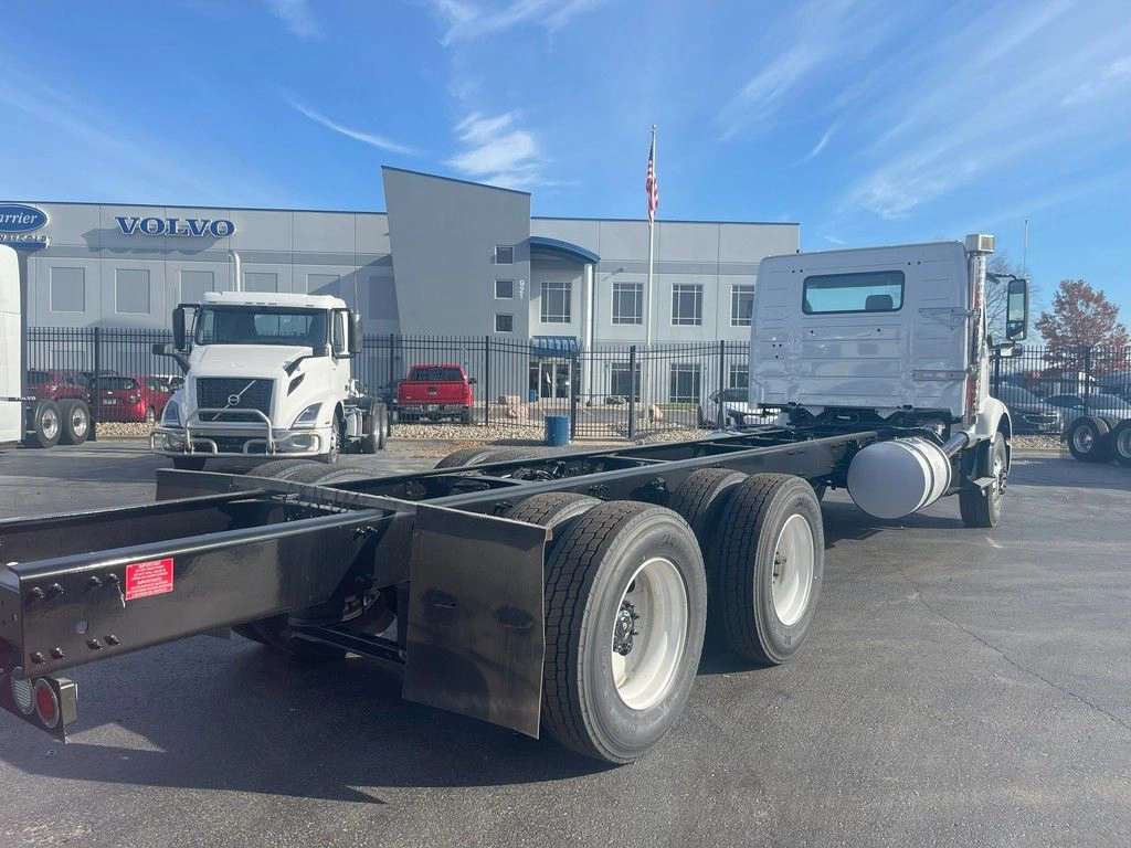 Rear passenger-side view of a white Volvo VNR chassis, showing dual rear axles and frame rails.