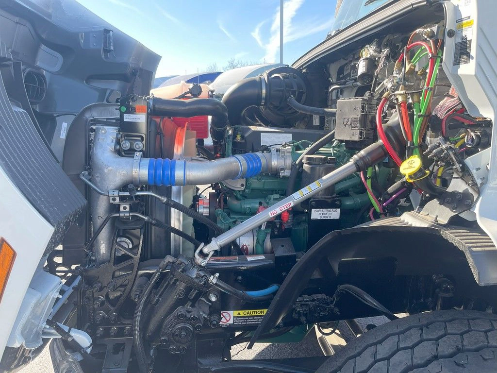 Volvo VNR engine compartment with hood open, showing engine components and hoses.