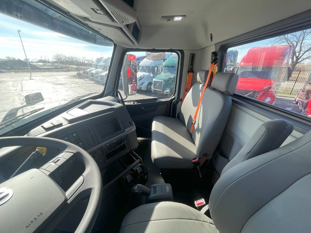 Volvo VNR cab interior showing gray seats, dashboard and passenger-side window view.