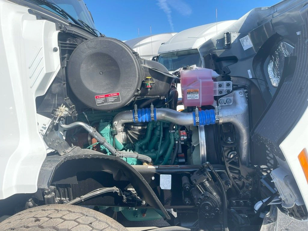 Volvo VNR engine bay with hood open, showing coolant tank, air intake and engine components.