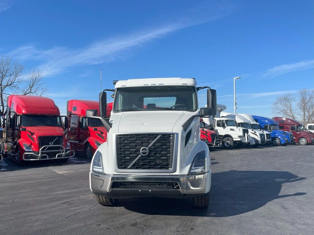 Front view of a white Volvo VNR day cab truck parked in a dealership lot.
