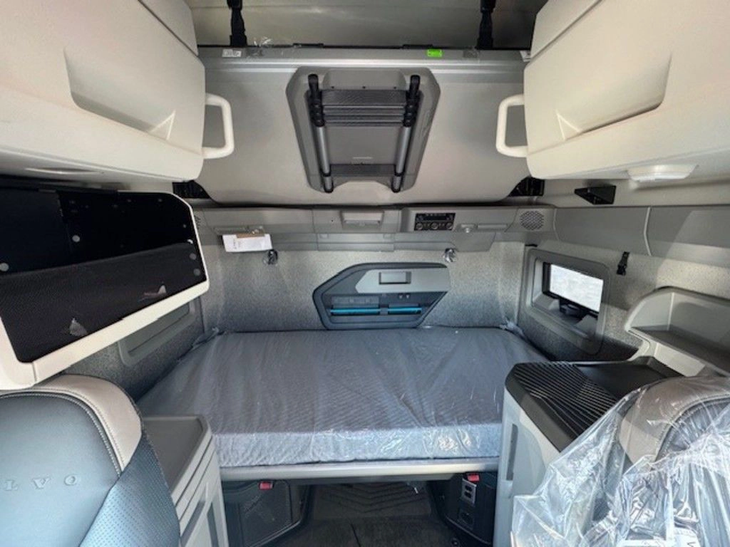 Volvo VNL sleeper area with lower bunk, upper storage cabinets and built-in comfort features.