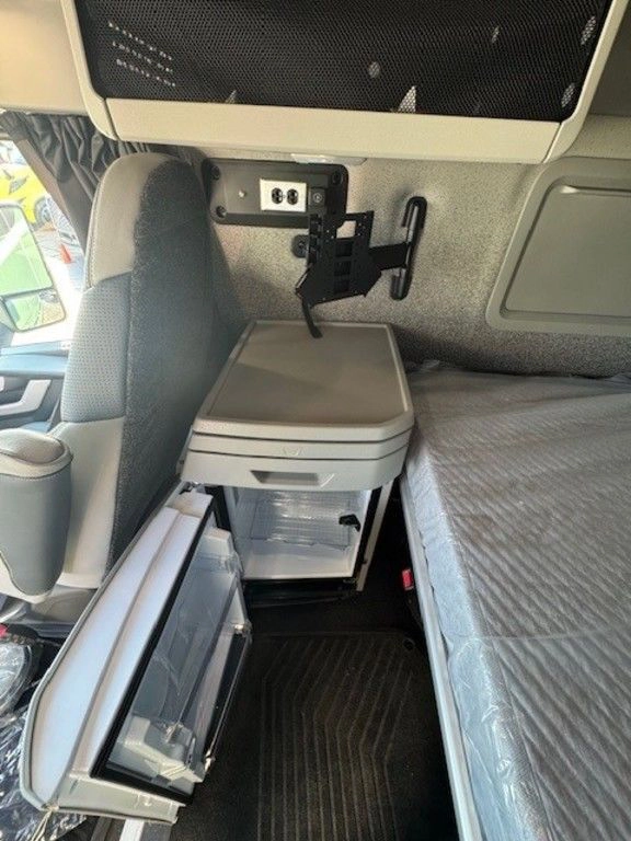 Volvo VNL sleeper interior with bunk, side storage, power outlets and mounted entertainment bracket.