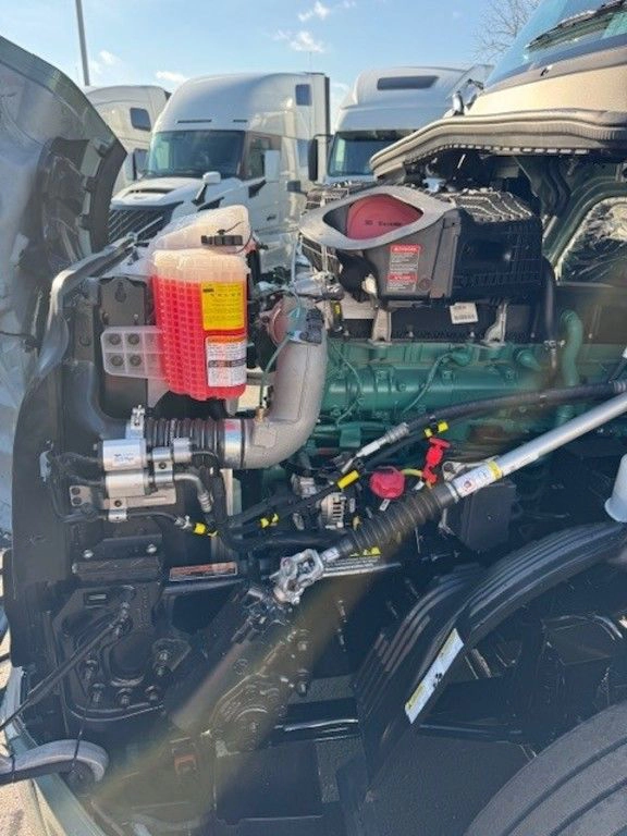 Close-up of the Volvo truck engine bay showing intake, coolant reservoir, hoses, and engine components.