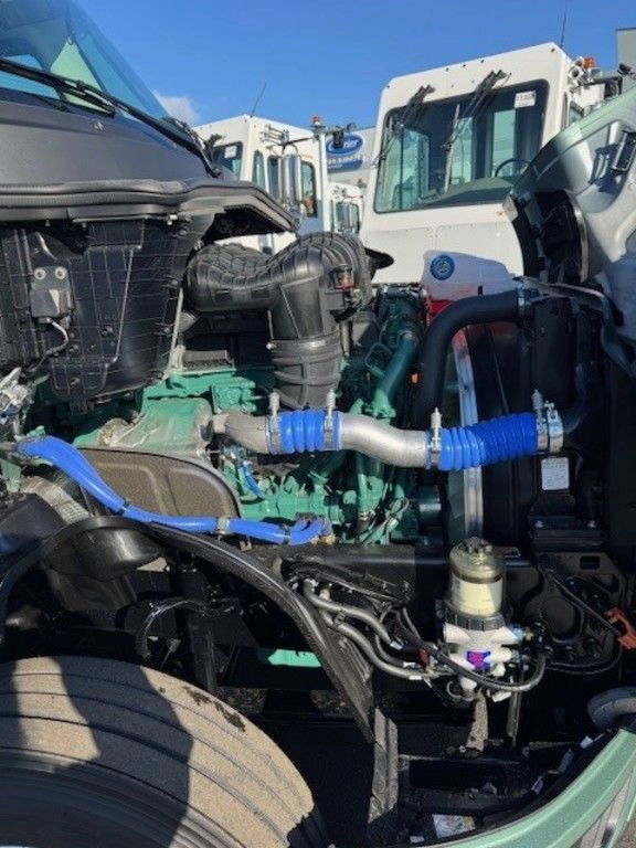 Close-up of the Volvo engine bay from the side, showing hoses, filters, and chassis components.