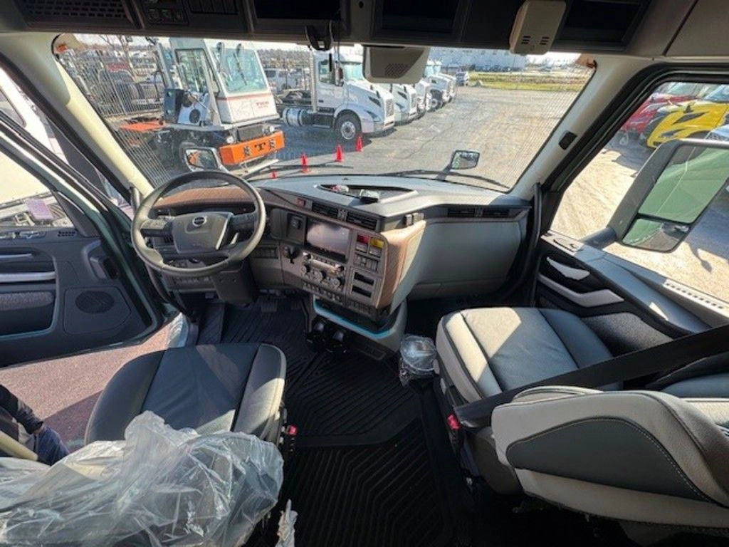 Wide view of the Volvo VNL cab interior showing driver and passenger seats, dashboard and windshield visibility.