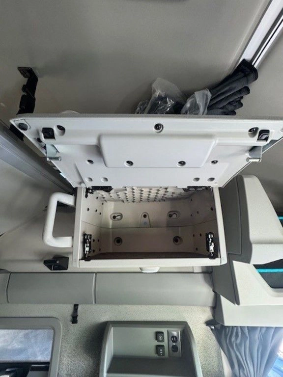 Open overhead storage cabinet inside a Volvo sleeper cab.