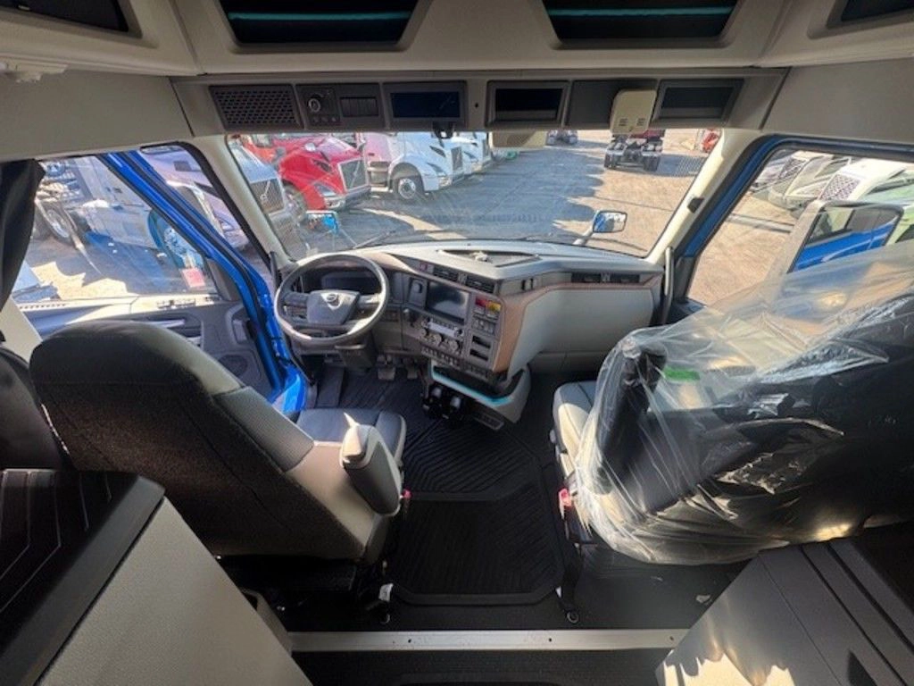 Volvo truck cab interior showing driver and passenger seats from the sleeper area.