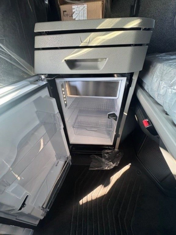 Open refrigerator compartment inside a Volvo sleeper cab.