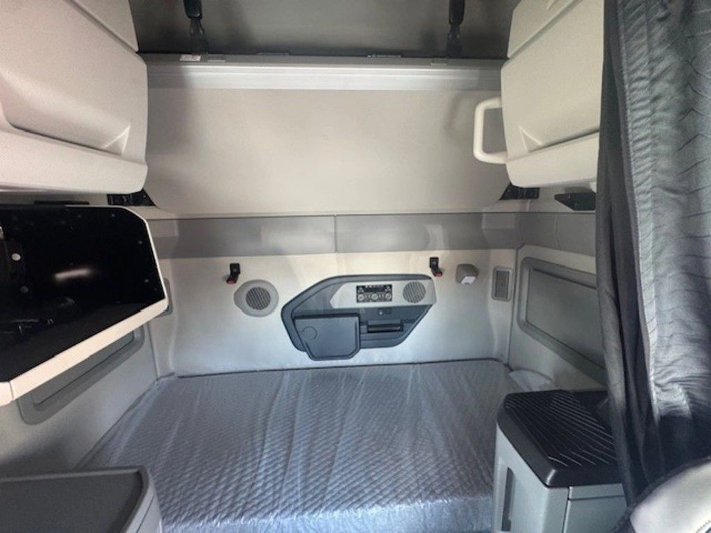 Sleeper bunk area in the Volvo VNL660 with mattress platform, storage and rear wall controls.