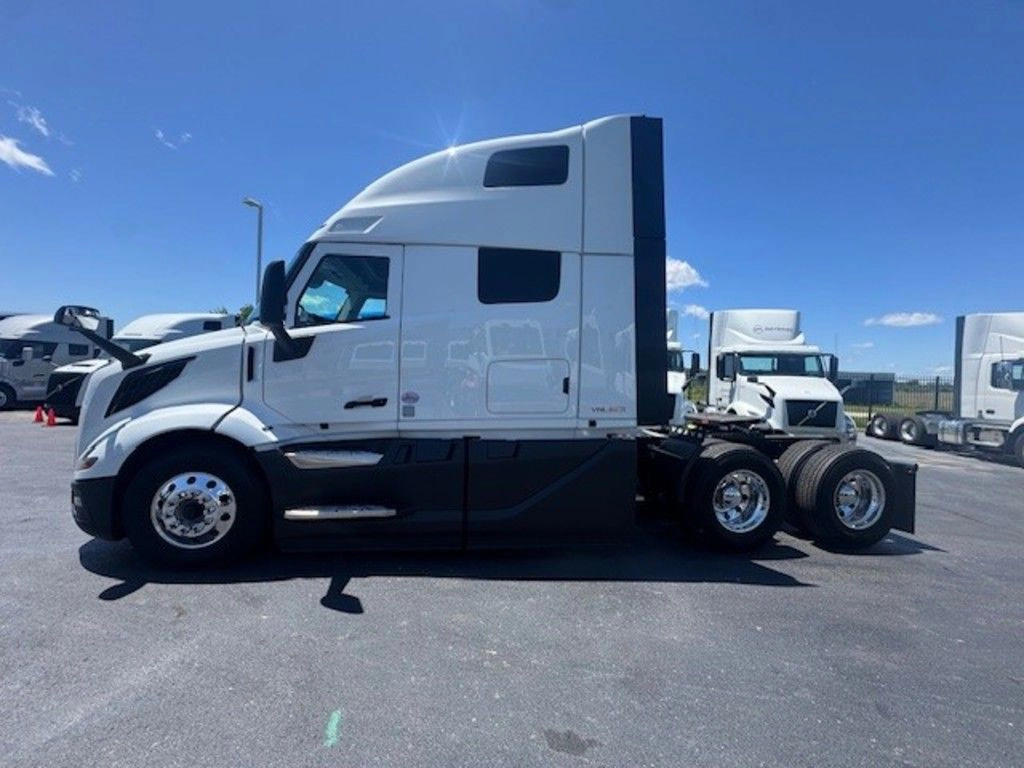 Driver-side profile of the white Volvo VNL660 sleeper tractor showing the high-roof cab and tandem axles.