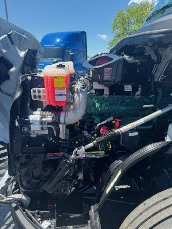 Engine bay detail on the Volvo VNL660 showing fluid reservoirs, hoses and under-hood components.