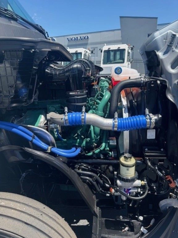 Volvo VNL660 engine compartment showing hoses, filters and engine components beneath the raised hood.