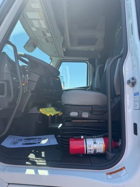 Driver-side cab entry showing the seat, step area and fire extinguisher inside the Volvo VNL660 sleeper.