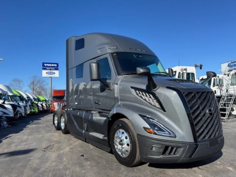 Three-quarter front view of gray Volvo VNL sleeper tractor on the dealership lot.