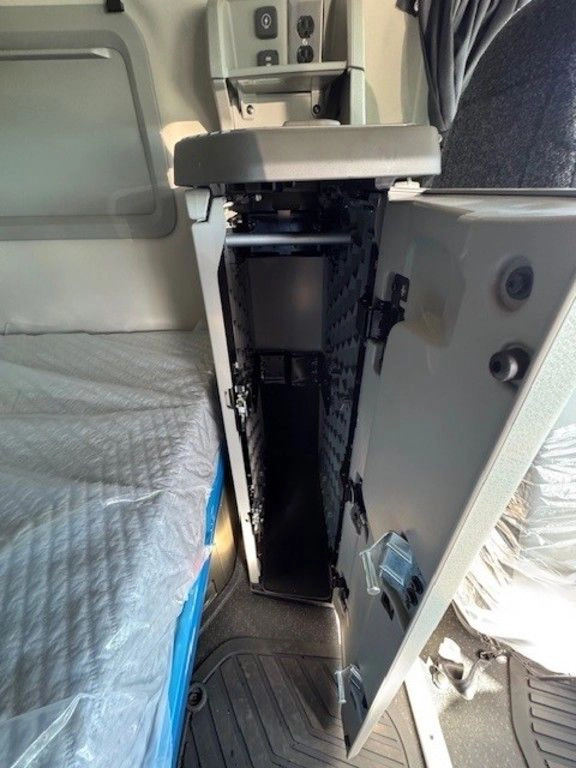 Open vertical storage cabinet inside the Volvo VNL sleeper area next to the bunk.