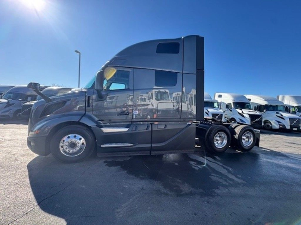 Driver-side profile of gray Volvo VNL sleeper tractor with tandem rear axles.