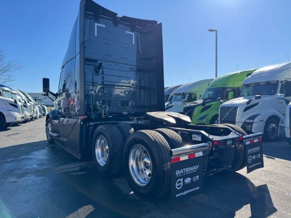 Rear three-quarter view of gray Volvo VNL sleeper tractor with fifth wheel and tandem axles.