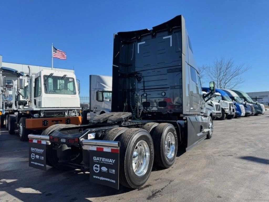 Rear view of gray Volvo VNL sleeper tractor showing frame, fifth wheel and rear mudflaps.