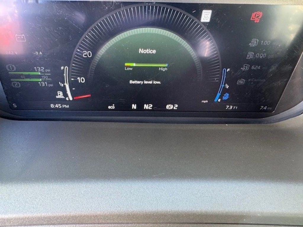 Close-up of Volvo VNL digital gauge cluster displaying a battery level notice.
