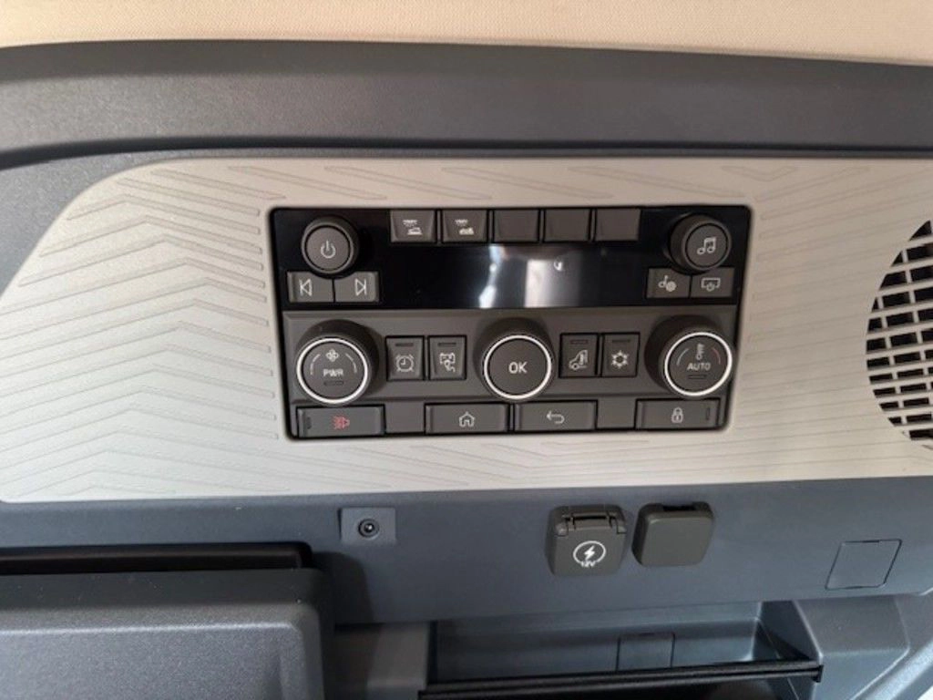 Close-up of Volvo VNL sleeper climate control panel with display, buttons and vents.