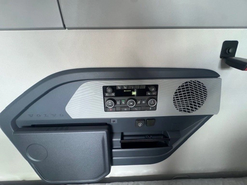 Sleeper wall control panel with audio controls, speaker, storage pocket and small outlet.