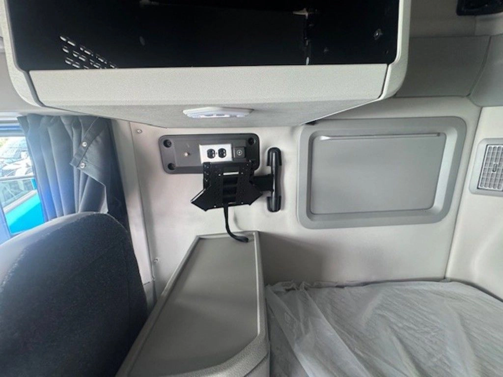 Volvo VNL sleeper cabinet area with mounted accessory bracket, outlet panel and storage compartment.