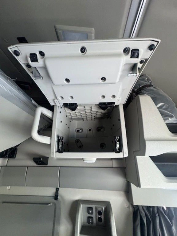 Open overhead storage bin inside the Volvo VNL sleeper, showing interior shelving and latch details.