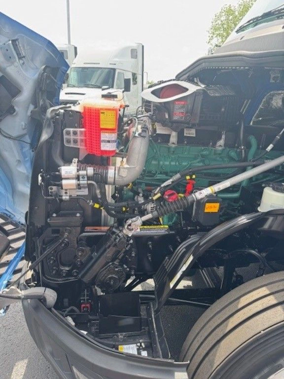 Open hood view of the Volvo VNL engine compartment showing components and service access points.