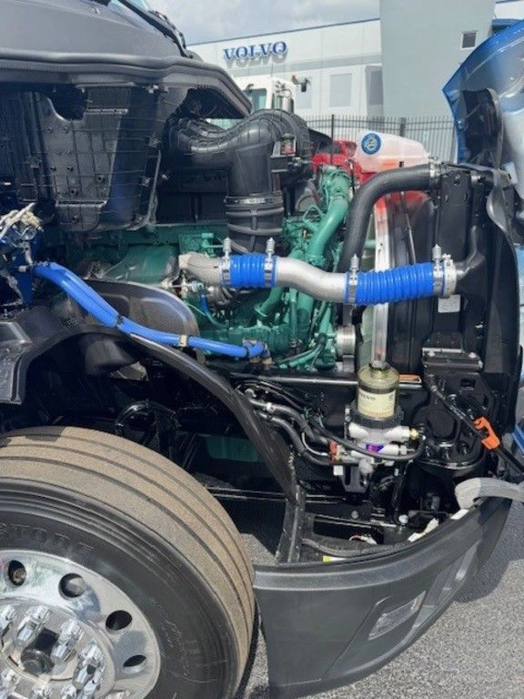 Close-up of the Volvo VNL engine bay with hoses, filters and major components visible for inspection.