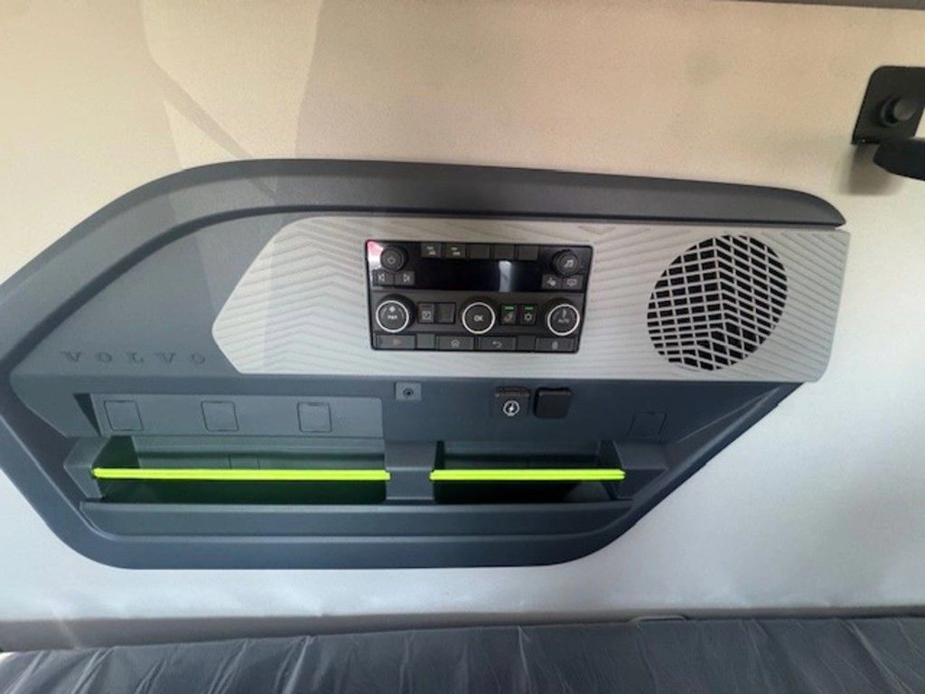 Close-up of the Volvo VNL sleeper control panel with vents, speaker, storage slot and comfort controls.