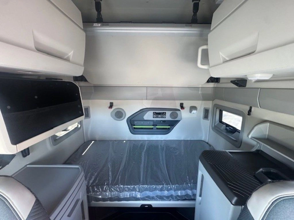 Volvo VNL sleeper area with lower bunk, upper cabinets, side storage and built-in driver comfort features.