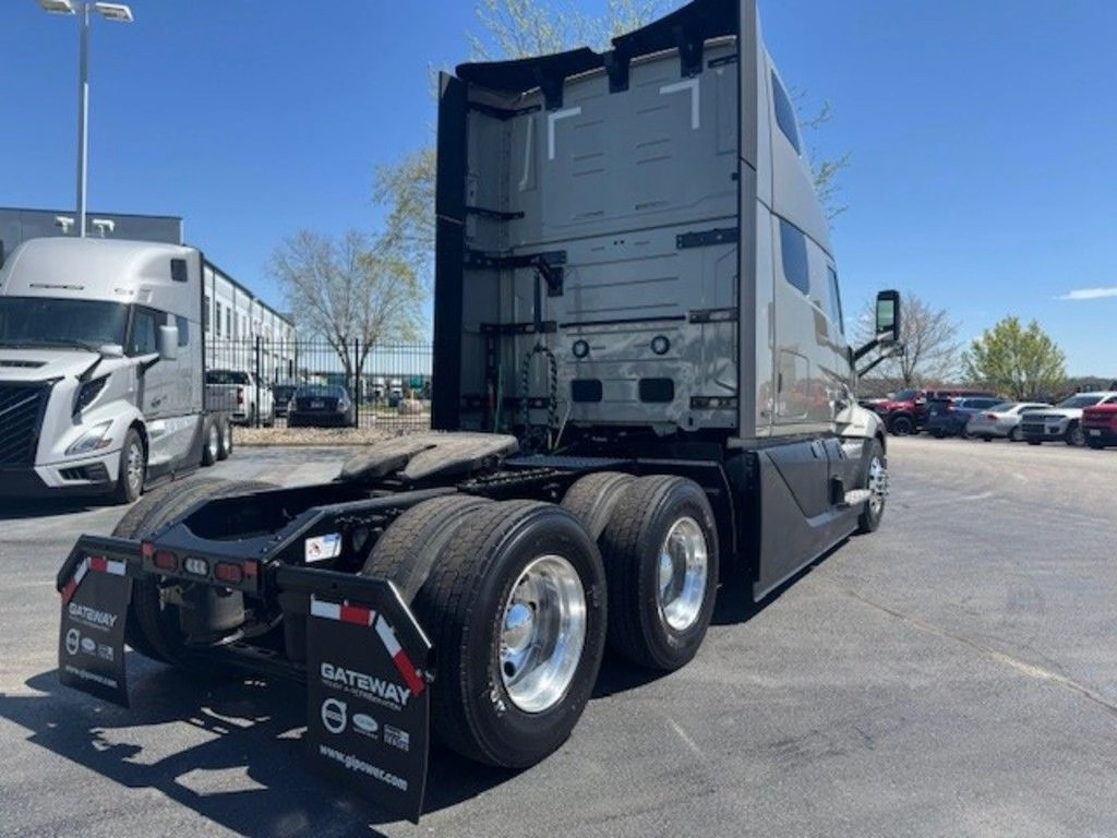 Rear three-quarter view of a Volvo VNL sleeper tractor showing tandem axles, fifth wheel and rear mud flaps.