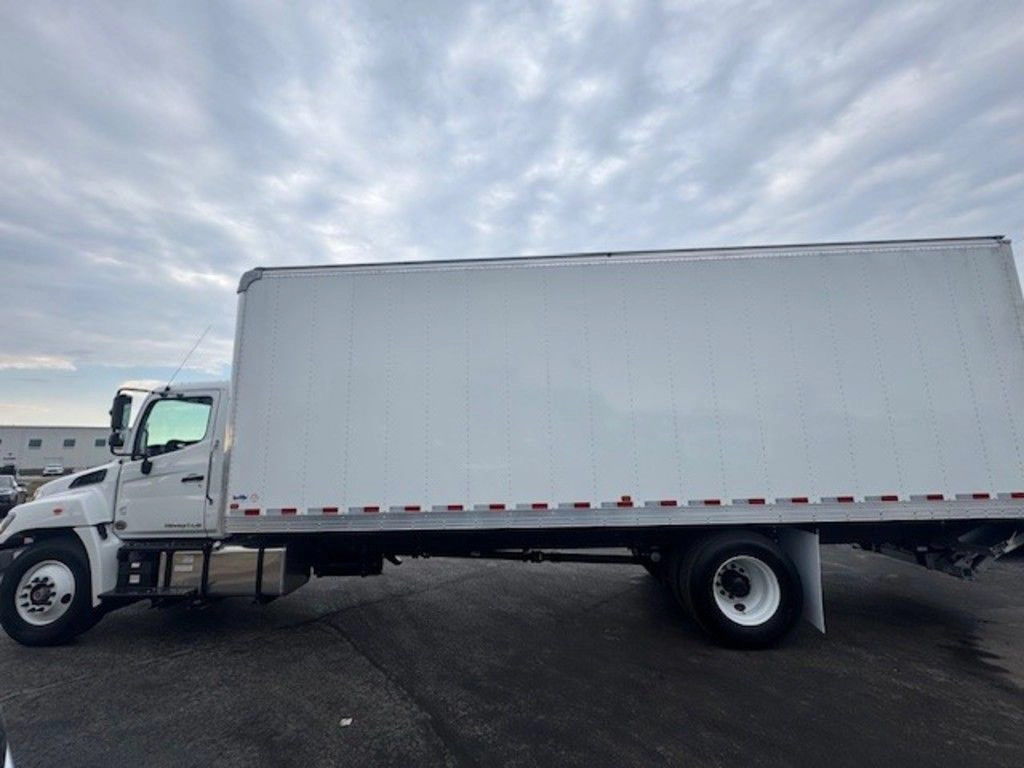 Driver-side view of the Hino L6 cargo box and chassis, showing the white body and underbody components.