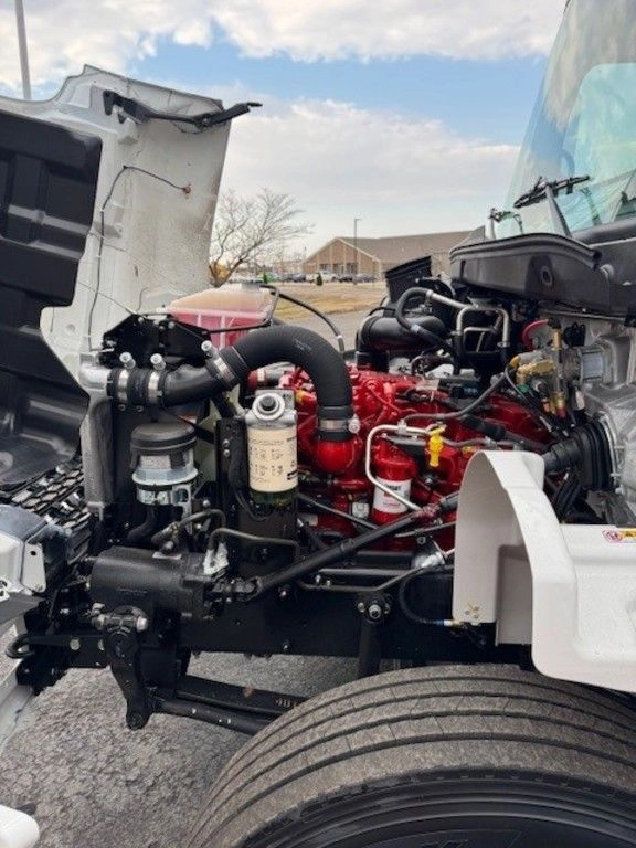 Close-up of the Hino L6 engine bay from the passenger side, showing filters, hoses and red engine components.