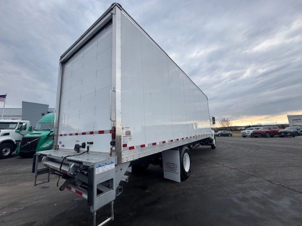 Rear passenger-side view of the white Hino L6 box truck, showing the liftgate and tall cargo box.