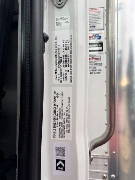 Close-up of the Hino L6 door jamb labels with vehicle specifications and safety information.