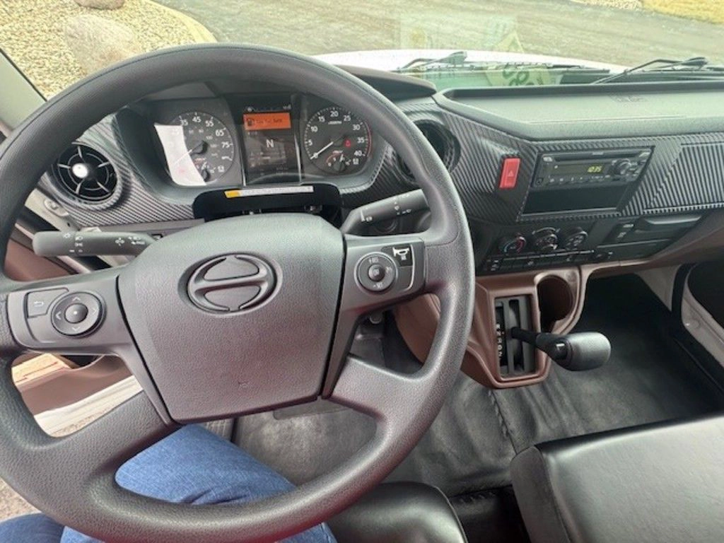 Driver’s view of the Hino L6 dashboard, steering wheel, gauges and center controls inside the cab.