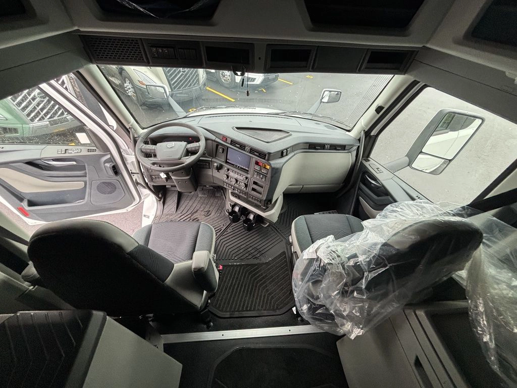 Elevated view of the Volvo VNL cab interior showing driver seat, steering wheel, dashboard and passenger seat.