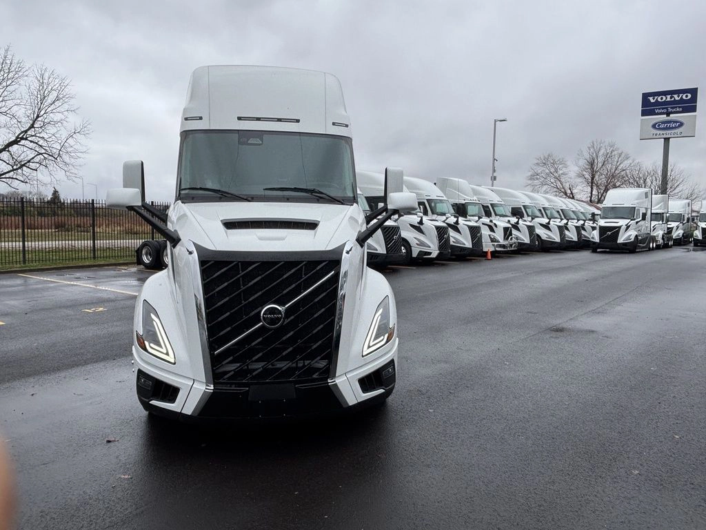 Front view of a white Volvo VNL sleeper truck parked on a dealership lot.