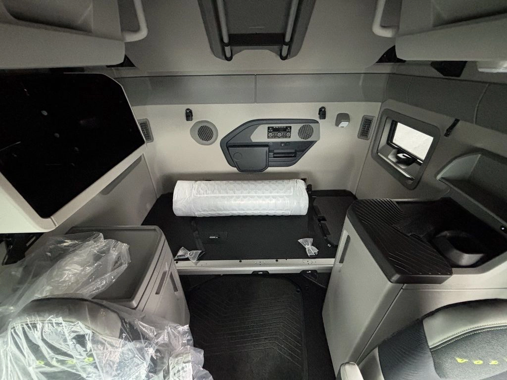 Volvo sleeper cab interior with bunk, cabinets and side storage area.