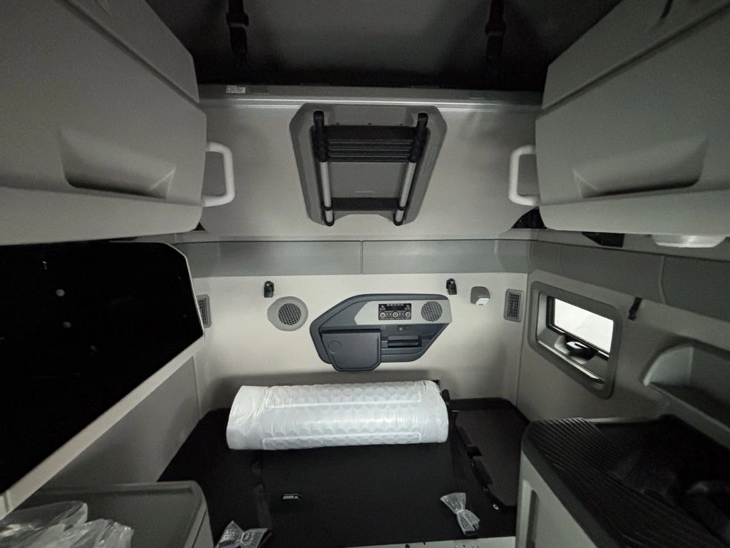 Volvo sleeper cab interior with upper storage, bunk area and side console.