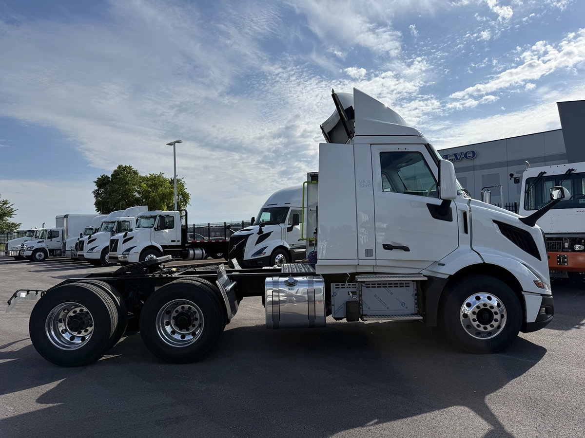 2027 Volvo VNR64T300 white day cab semi truck, full passenger-side profile view showing the sleek cab design and tandem rear axle configuration