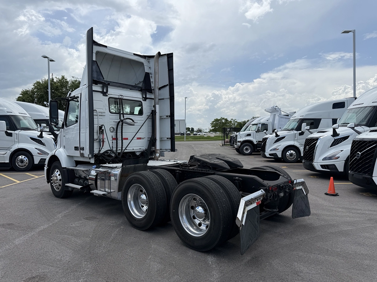 Rear three-quarter view of the Volvo VNR day cab from the passenger side, showing the back of the cab and tandem axles.