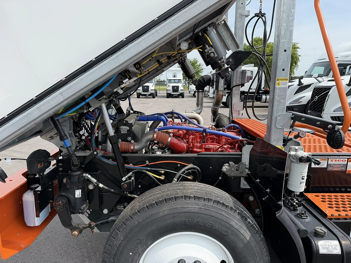 Engine compartment of a 2024 TICO Pro-Spotter with the hood raised, showing the diesel engine, wiring, and Cummins fuel filter.