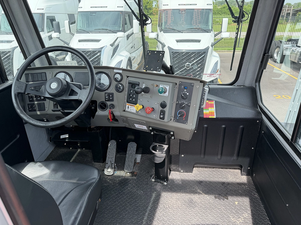 Interior cab view of a 2024 TICO Pro-Spotter showing the steering wheel, control panel, and joystick controls for yard operations.